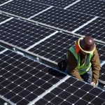 A man inspects solar panels.