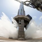 A view of SpaceX's starship system on the launchpad with the water-cooling flame deflector system active